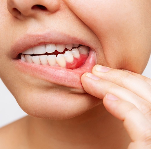Smiling dentist showing patient model of teeth