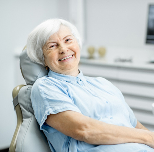 Senior woman sitting in dental chair and smiling