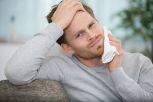 Man holding ice on his facial pain